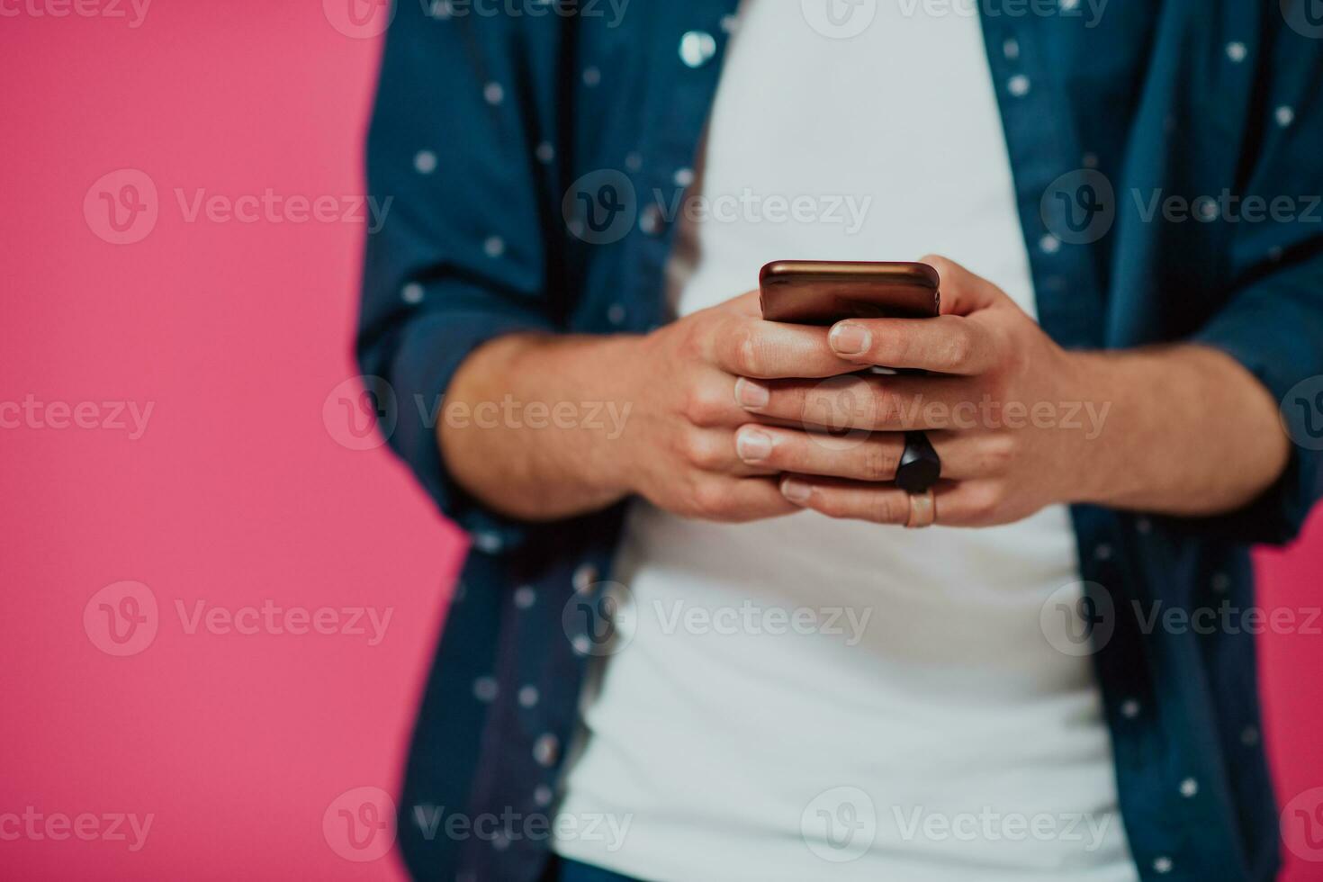 Portrait of a happy man using smartphone isolated over pink background. photo