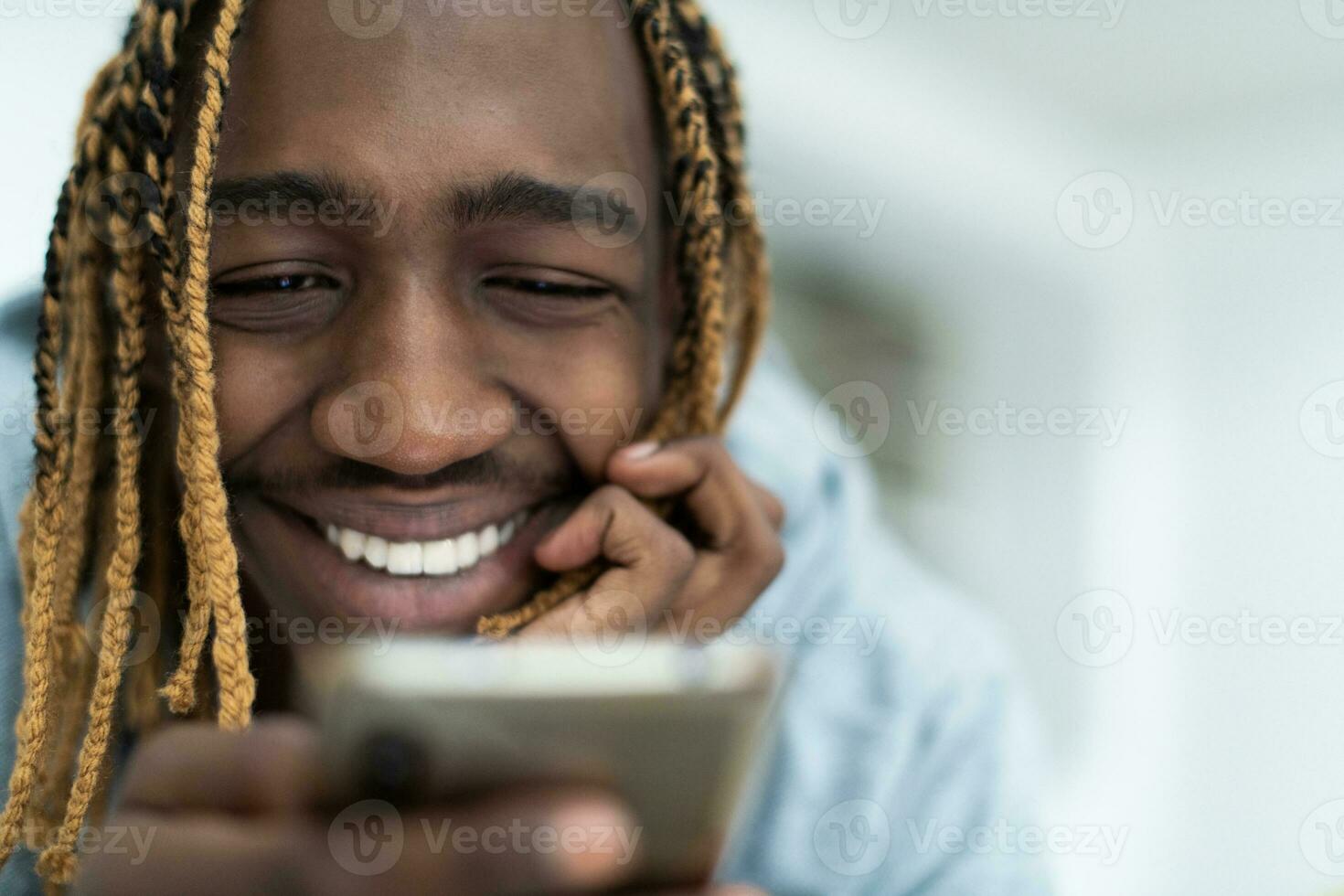 Afro guy using a smartphone and browses social media photo