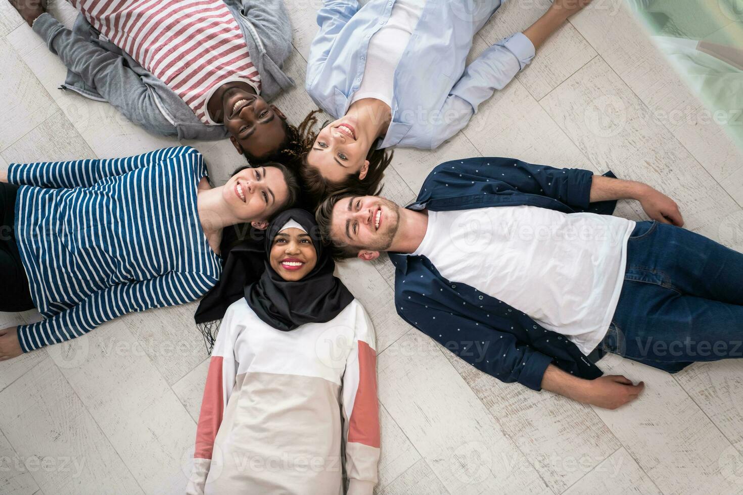 Top view of a diverse group of people lying on the floor and symbolizing togetherness photo