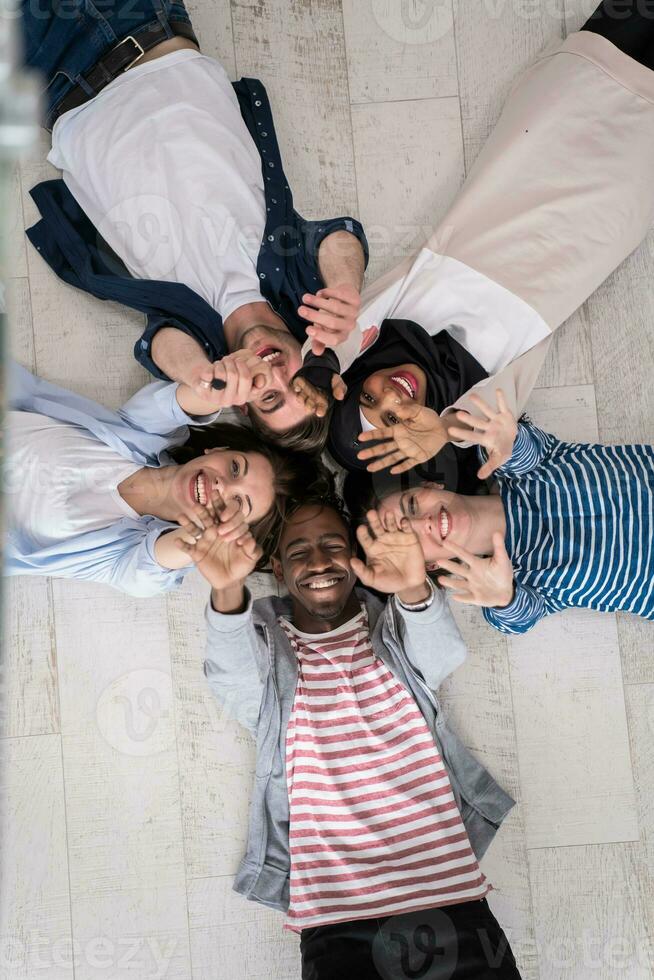 Top view of a diverse group of people lying on the floor and symbolizing togetherness photo