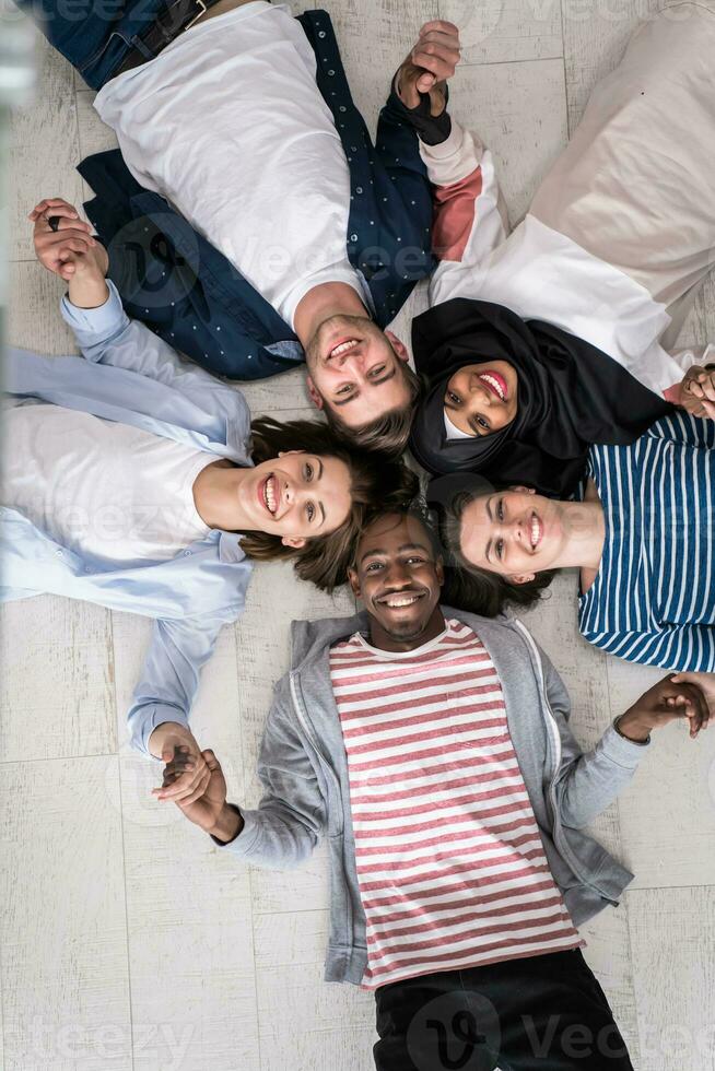Top view of a diverse group of people lying on the floor and symbolizing togetherness photo
