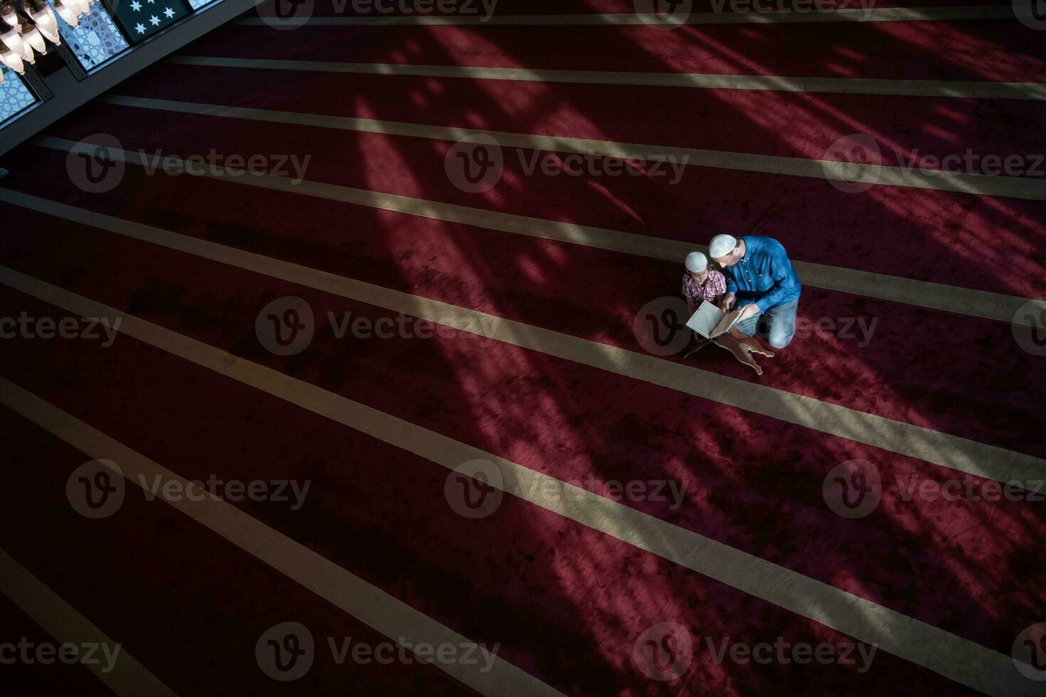 muslim prayer father and son in mosque praying and reading holly book quran together islamic education concept photo