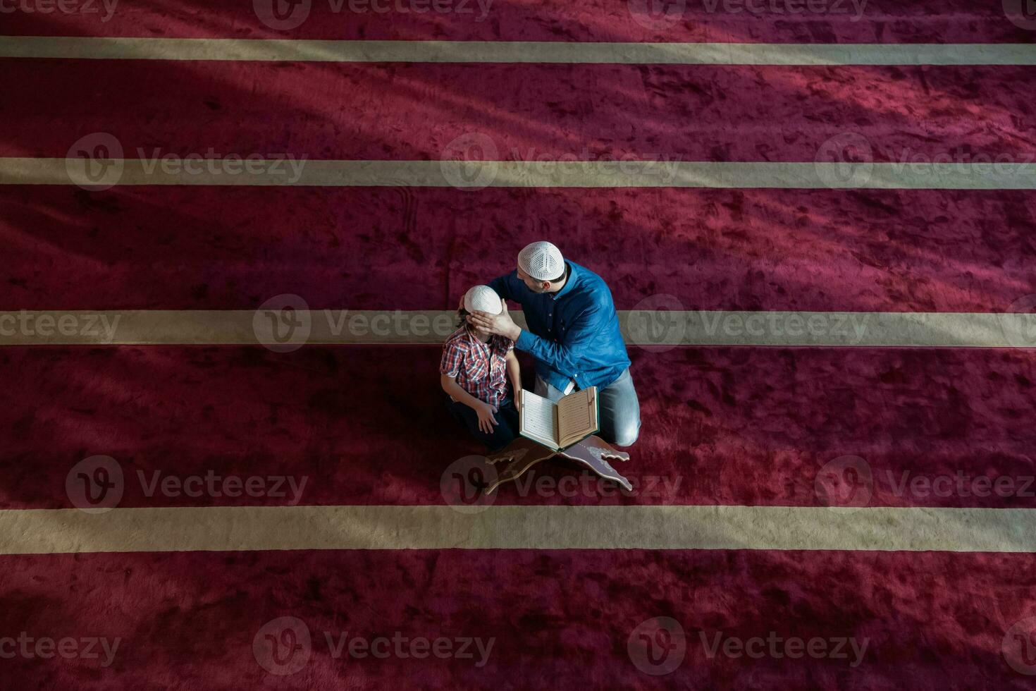muslim prayer father and son in mosque praying and reading holly book quran together islamic education concept photo