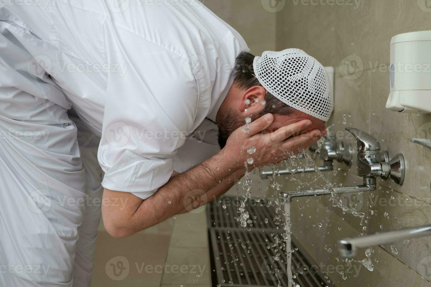 A Muslim takes ablution for prayer. Islamic religious rite photo