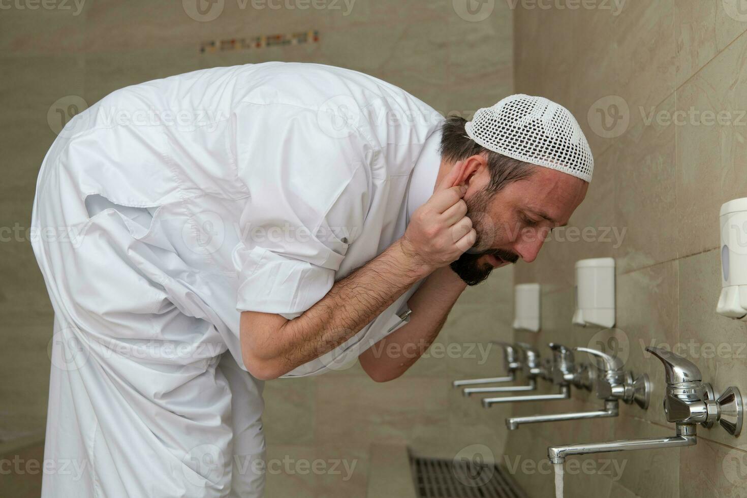 A Muslim takes ablution for prayer. Islamic religious rite photo