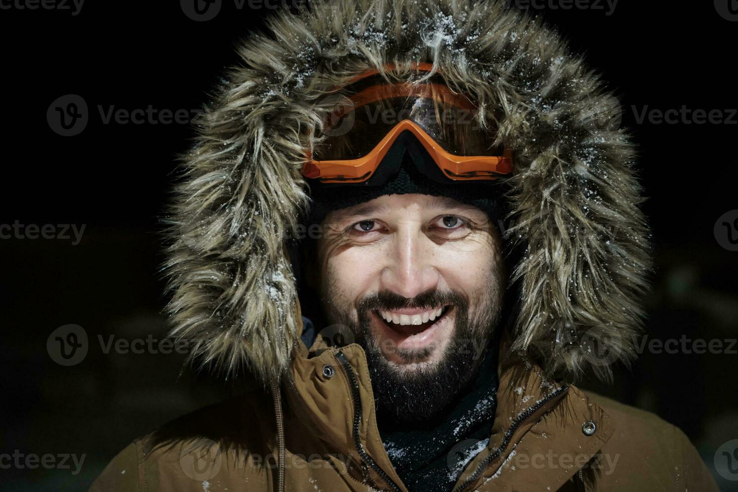 man at winter in stormy weather night  wearing warm  fur jacket photo