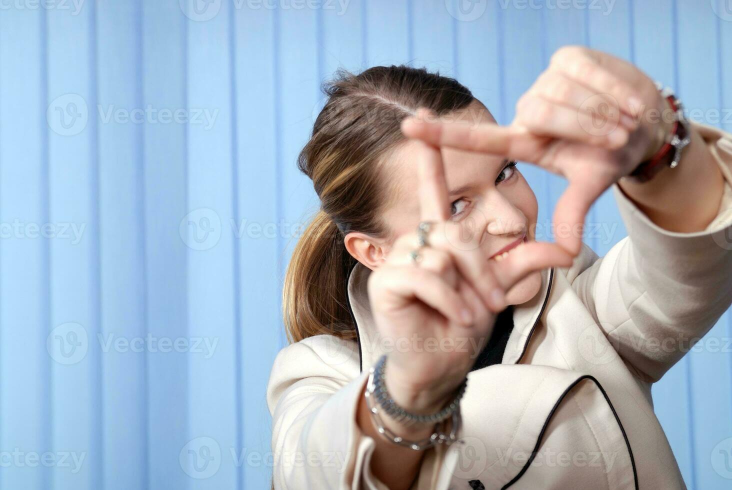 portrait of young business woman creates a frame with her hands photo