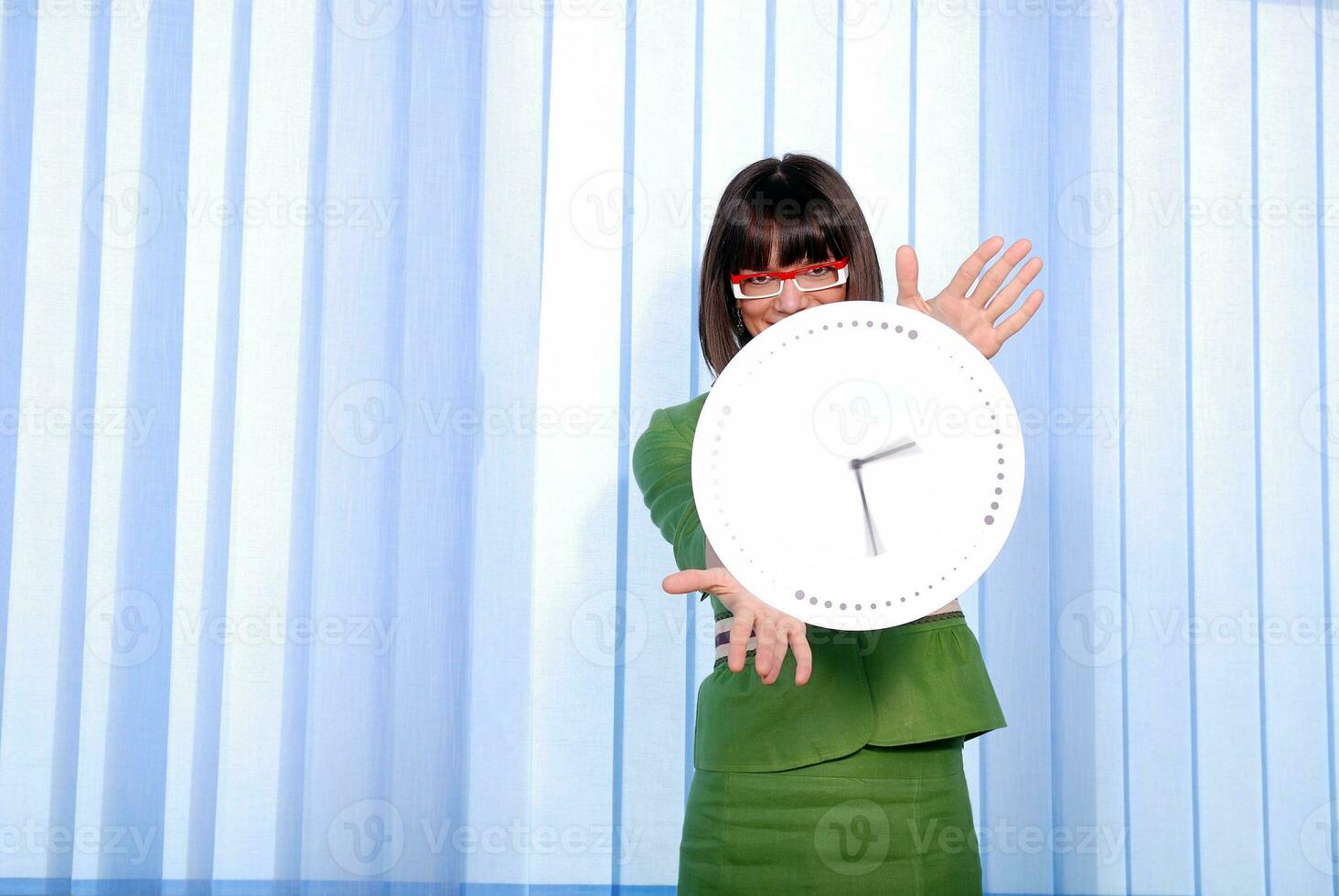 .a pretty business woman hiding behind a clock photo