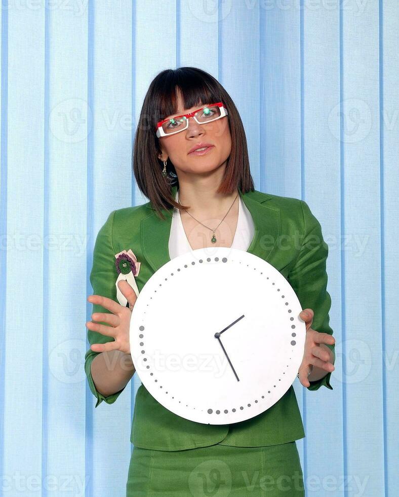 .a pretty business woman hiding behind a clock photo