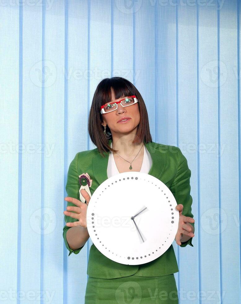 .a pretty business woman hiding behind a clock photo