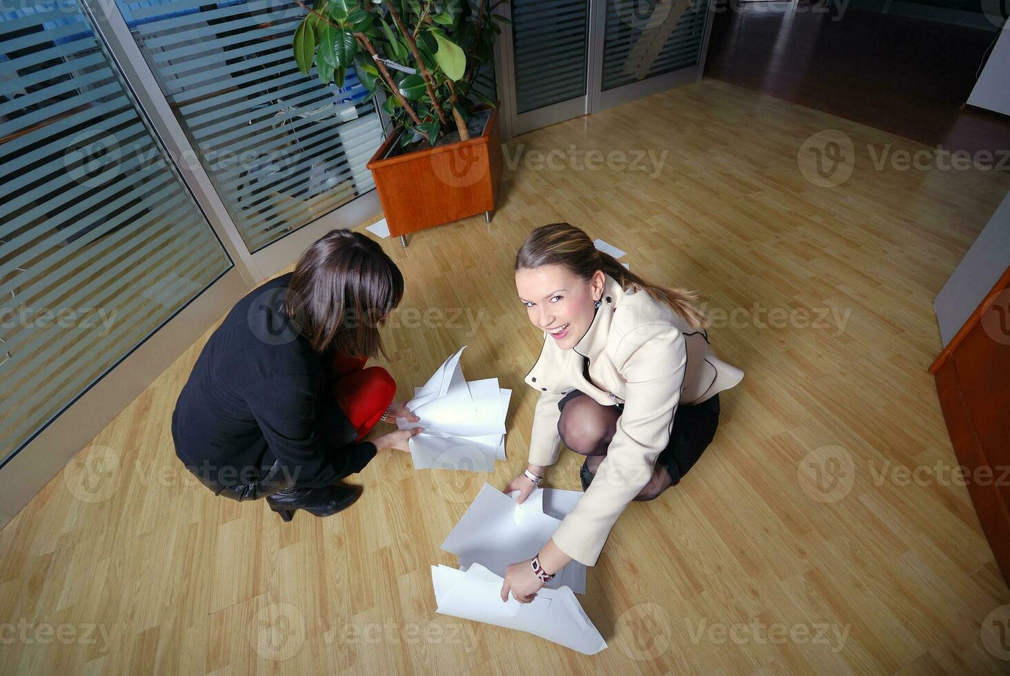 two businesswoman throw papers in office photo