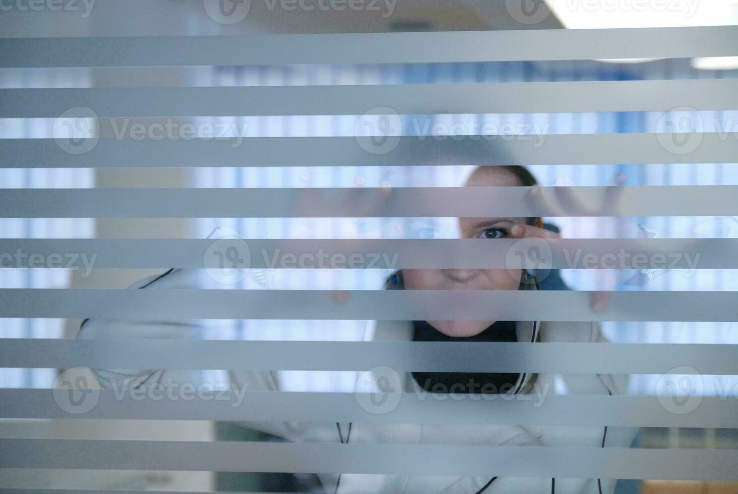 young businesswoman looking trought transparent wall photo