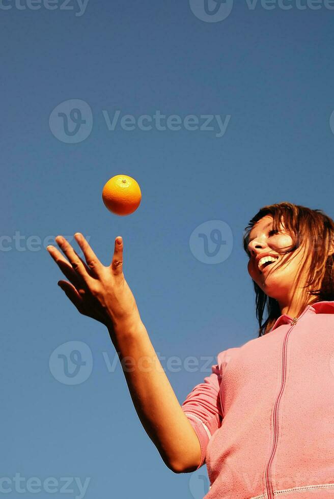 girl balancing orange in air photo