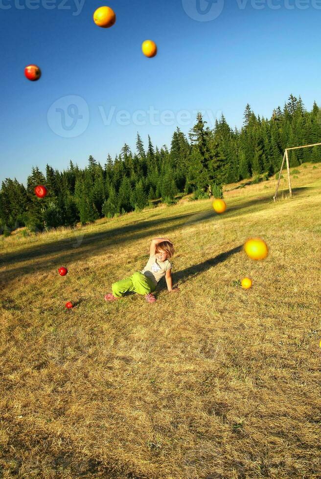 happy girl throwing apple outside photo