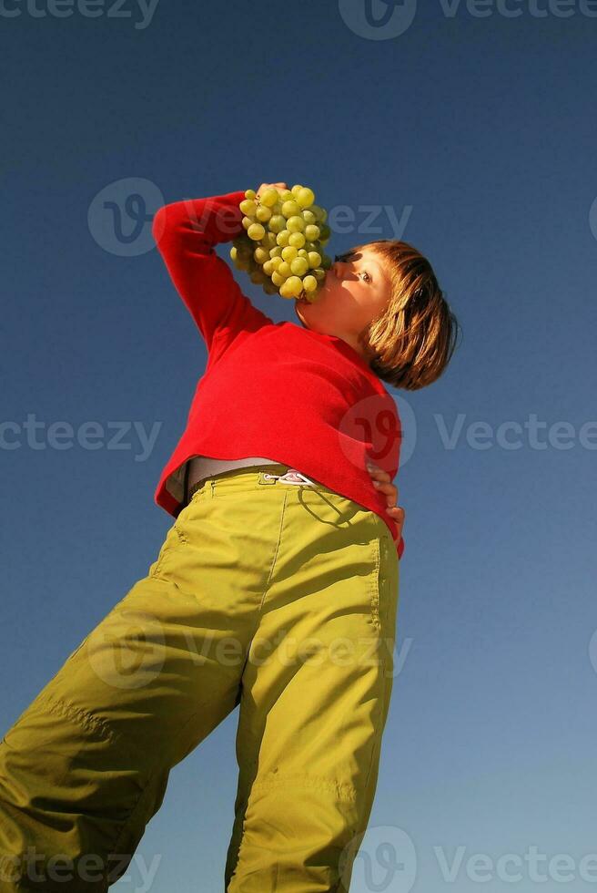 happy girl with grape outside photo