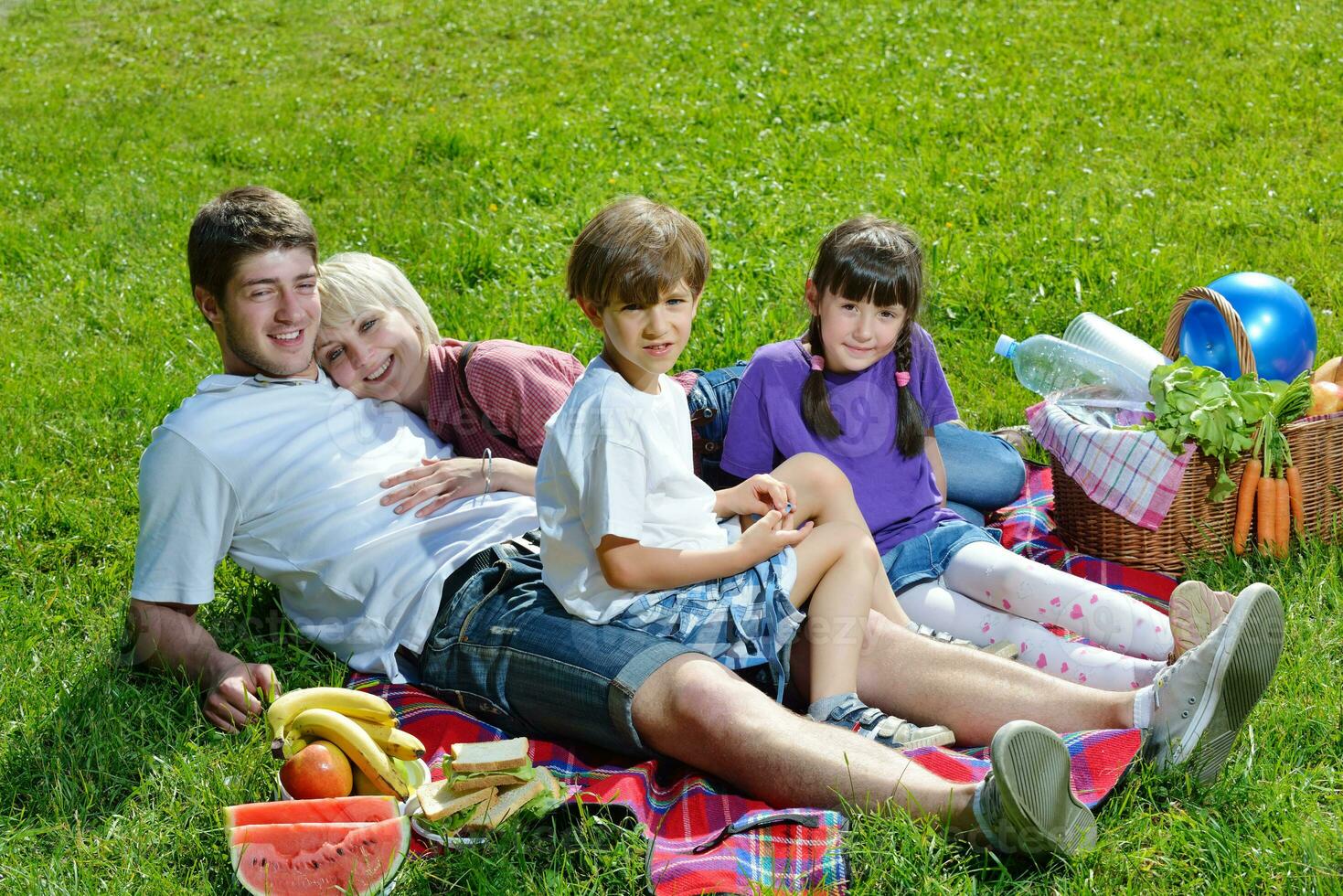 Happy family playing together in a picnic outdoors photo