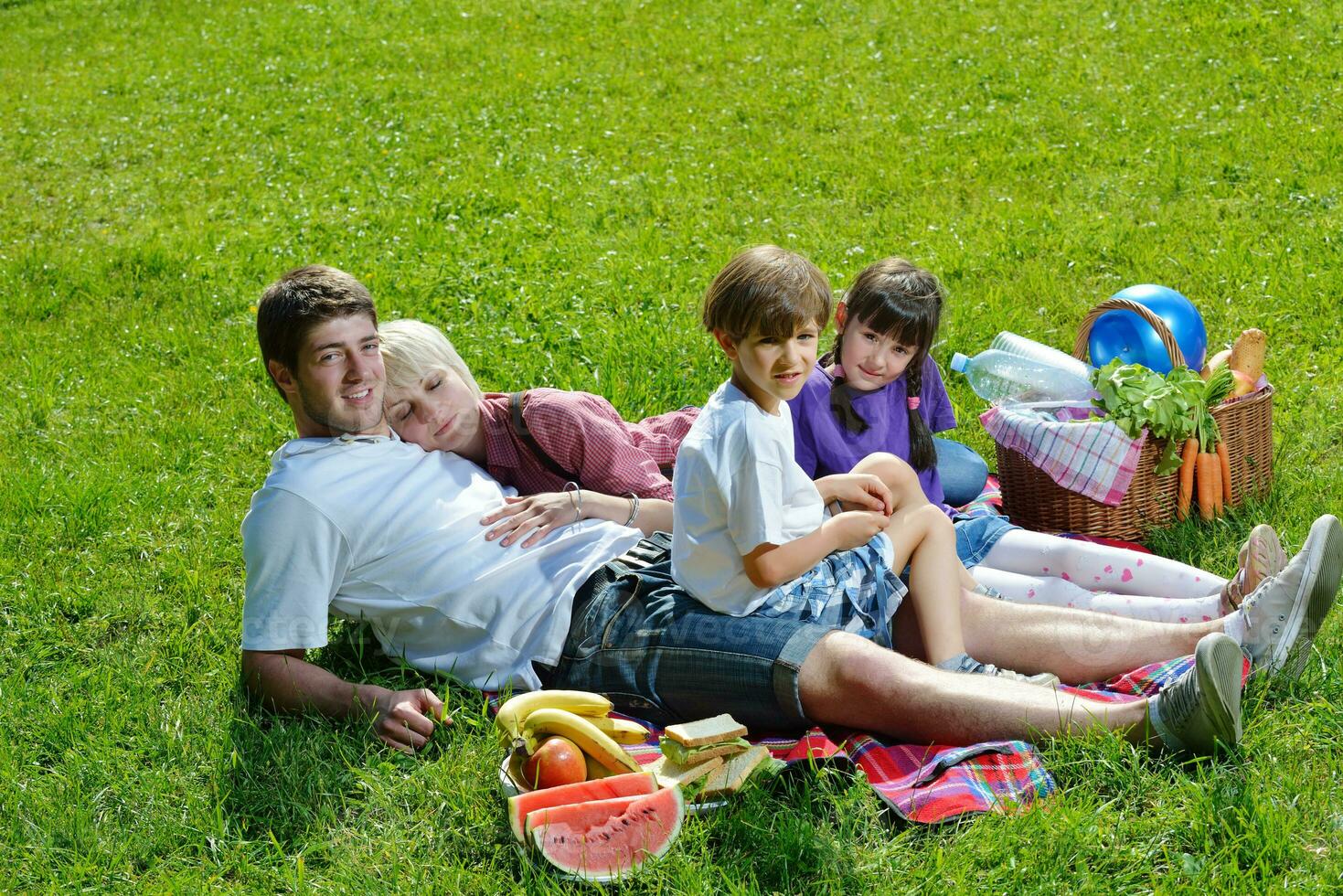 Happy family playing together in a picnic outdoors photo