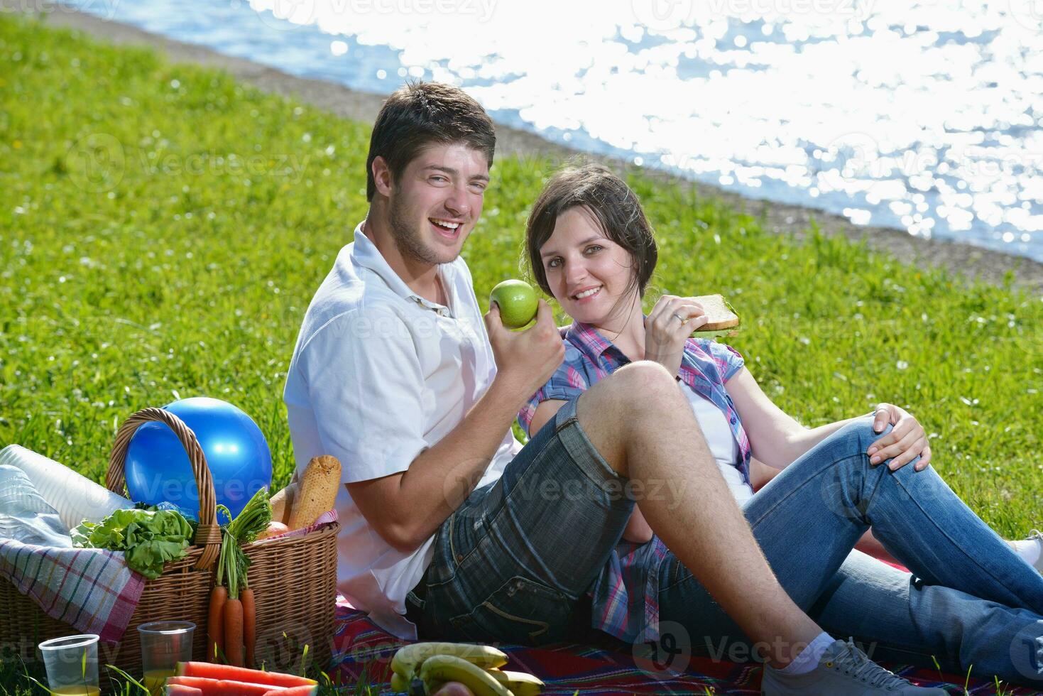 feliz pareja joven haciendo un picnic al aire libre foto