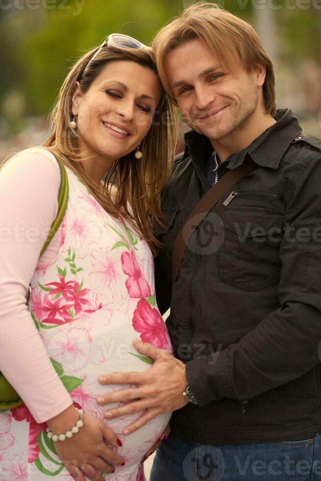 young pregnant couple have fun and relax photo