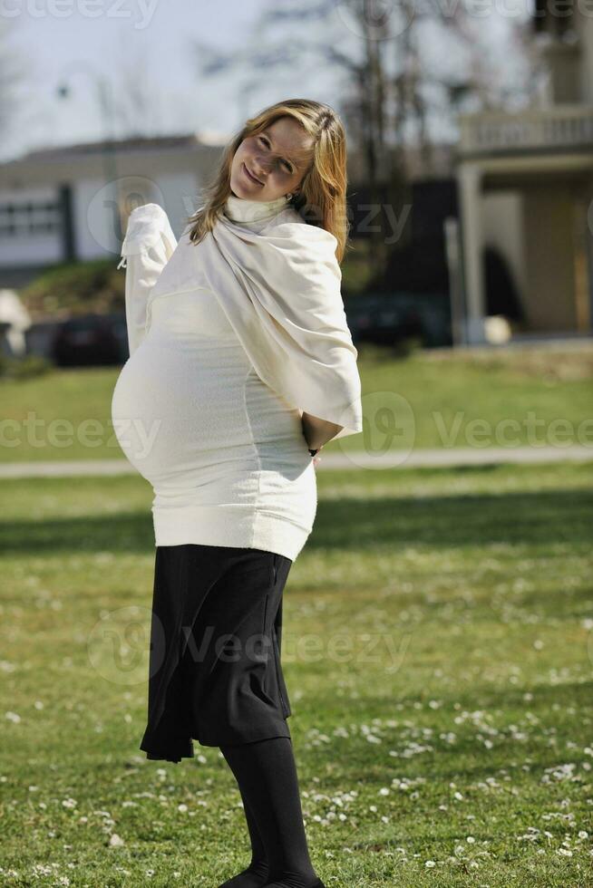 feliz joven mujer embarazada al aire libre foto