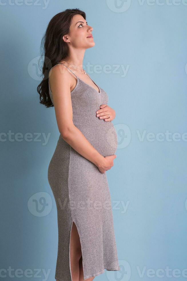 Portrait of pregnant woman over blue background photo