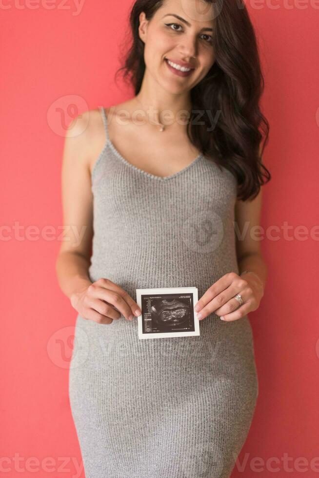 happy pregnant woman showing ultrasound picture photo