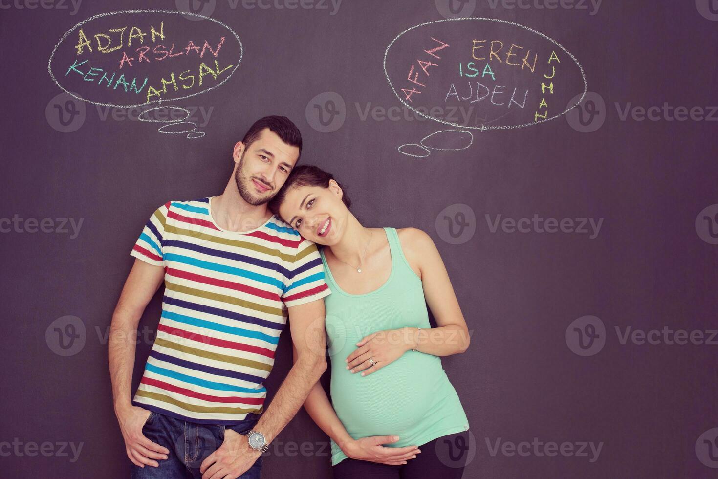 pregnant couple writing on a black chalkboard photo