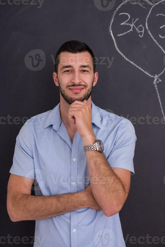 portrait of man in front of black chalkboard photo