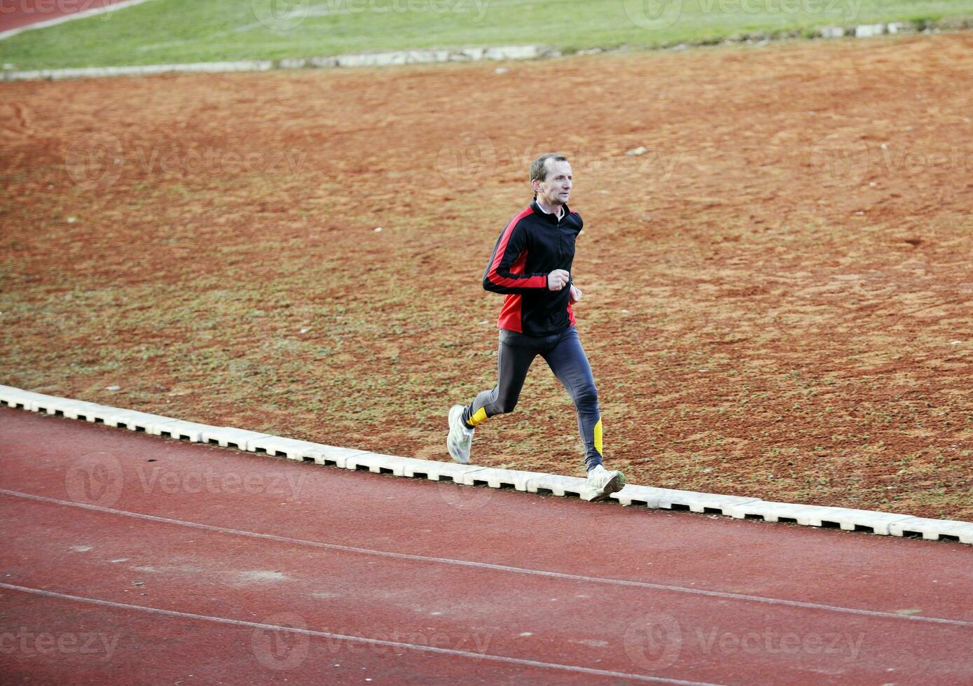 adult man running on athletics track photo