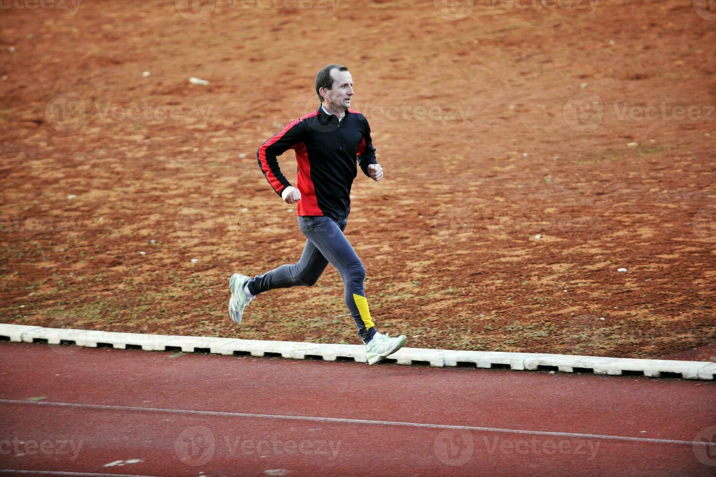 adult man running on athletics track photo