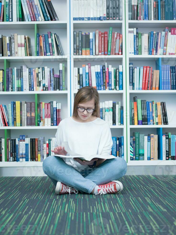 student girl reading book in library photo