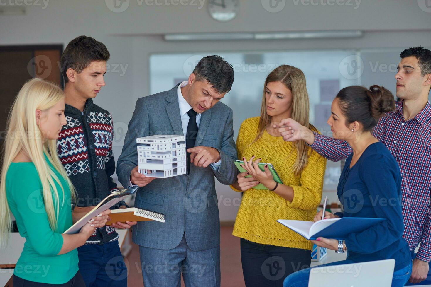 group of students working with teacher on  house model photo