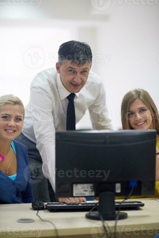 students with teacher  in computer lab classrom photo