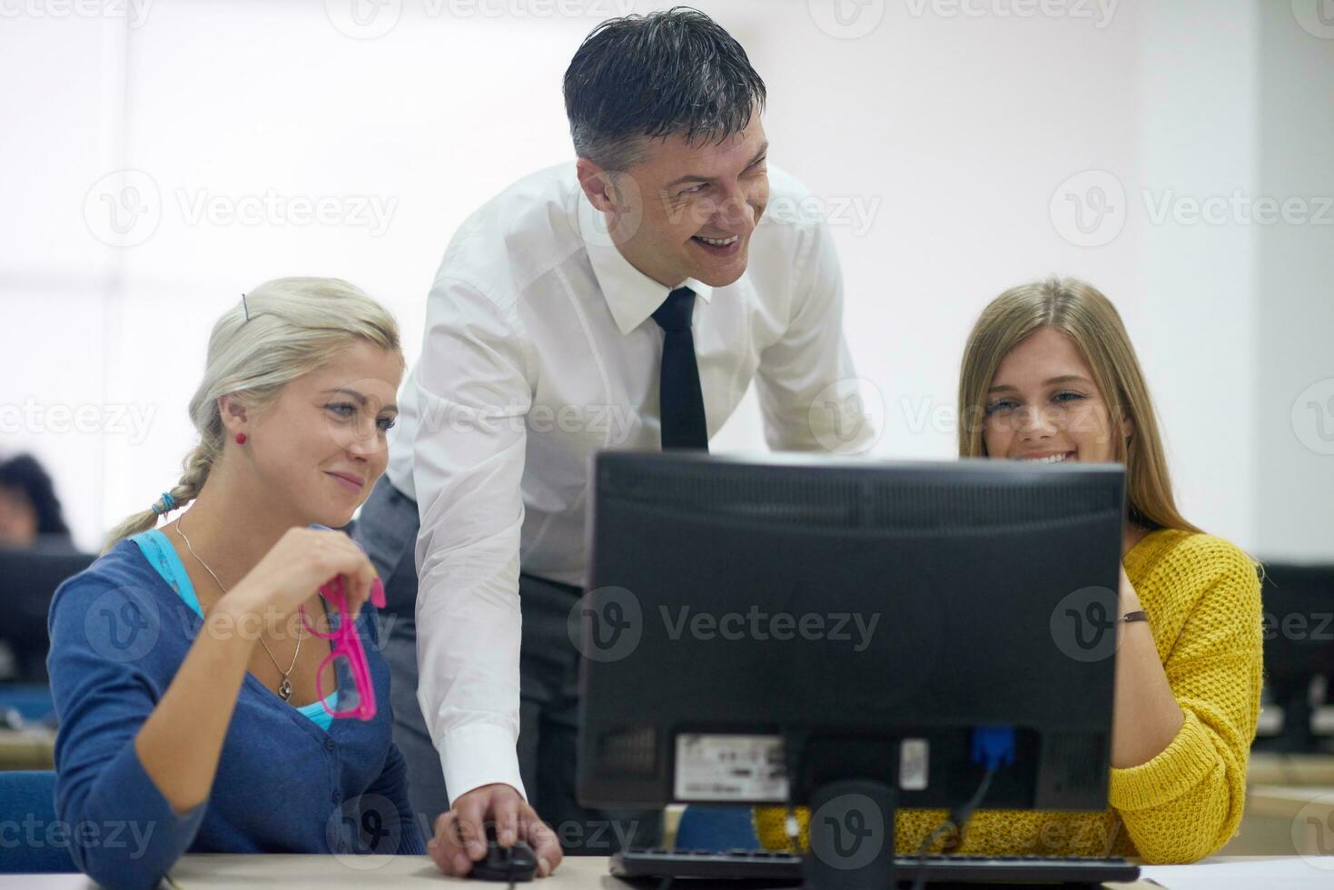 students with teacher  in computer lab classrom photo