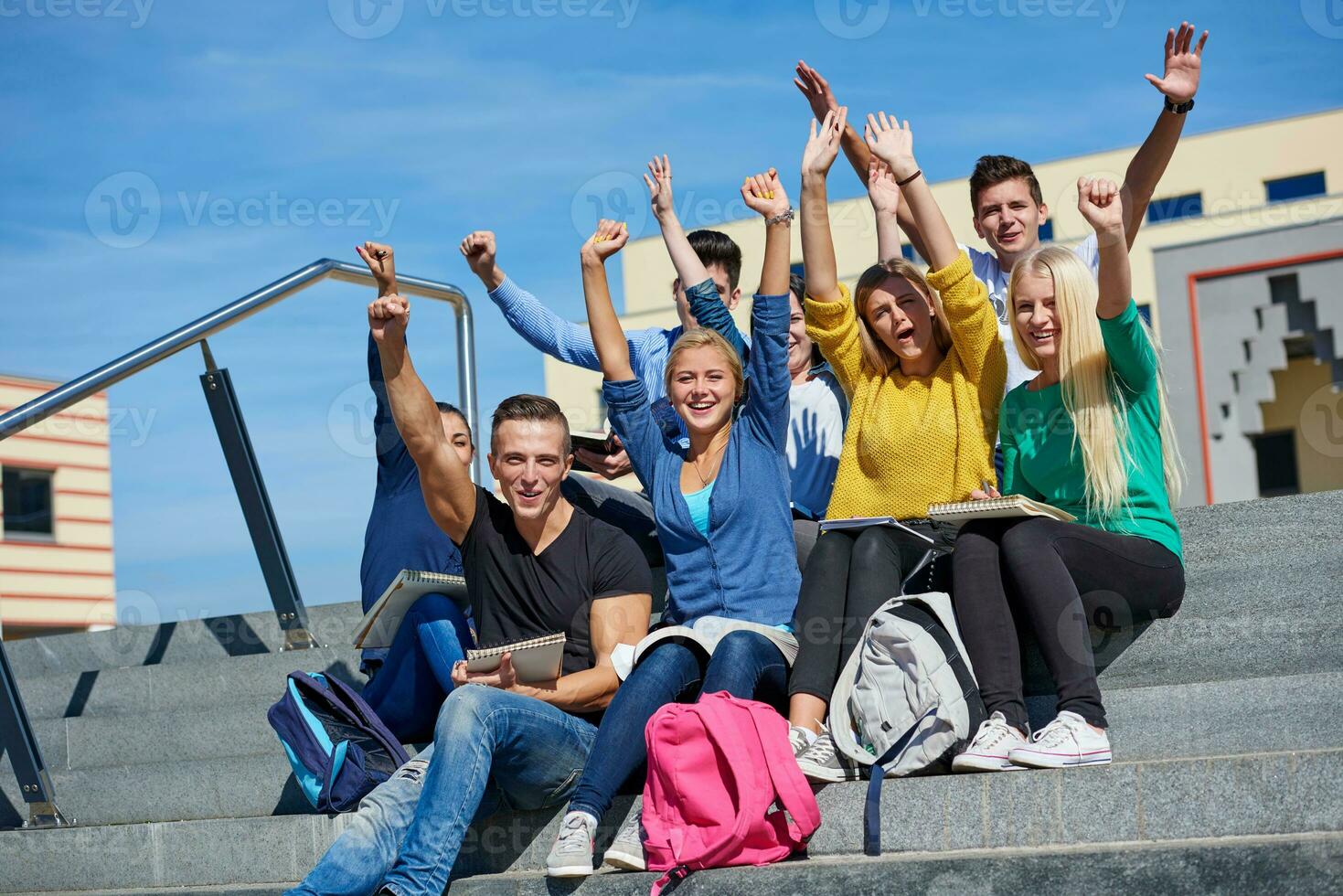 estudiantes afuera sentados en escalones foto