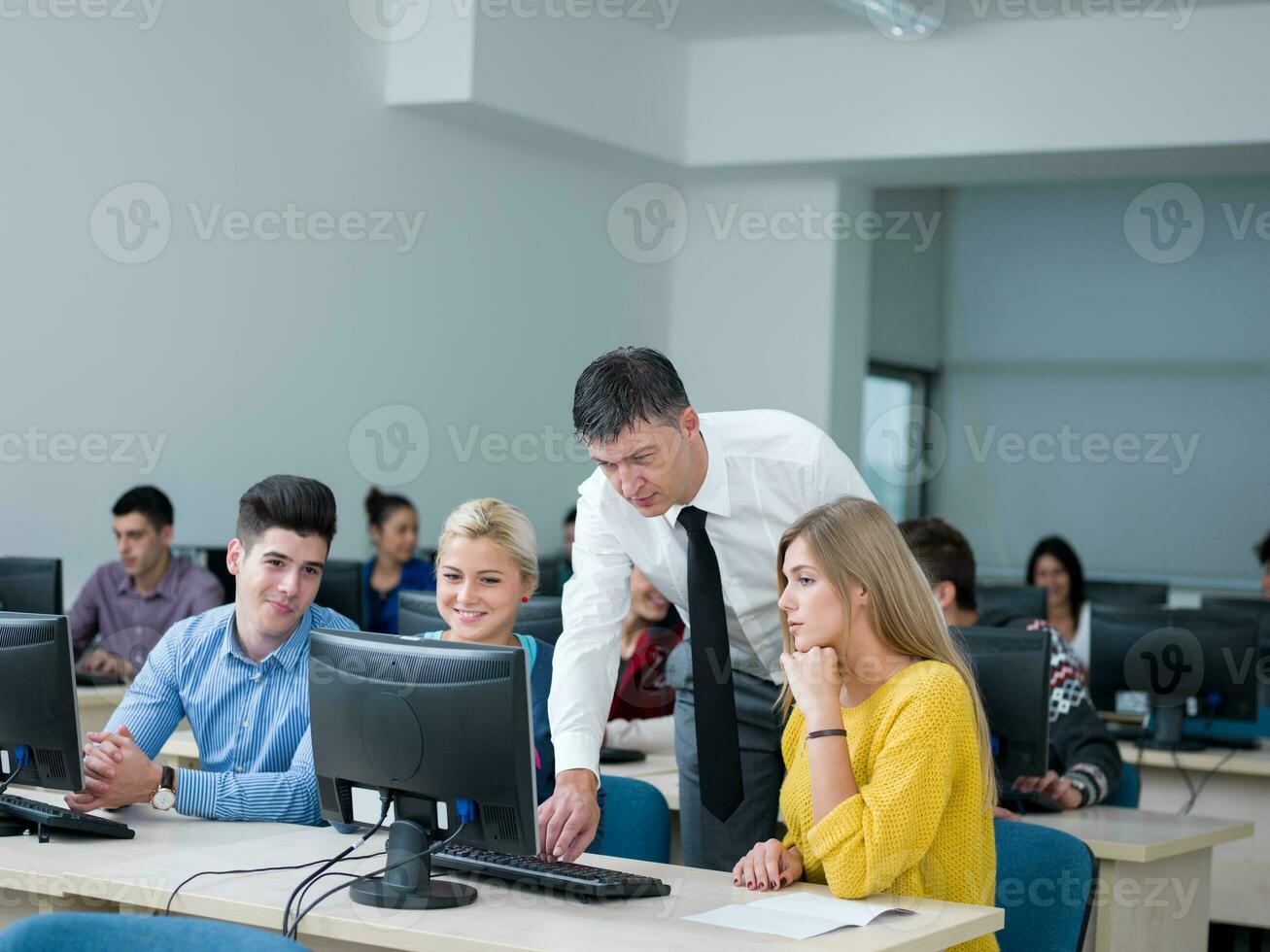 students with teacher  in computer lab classrom photo