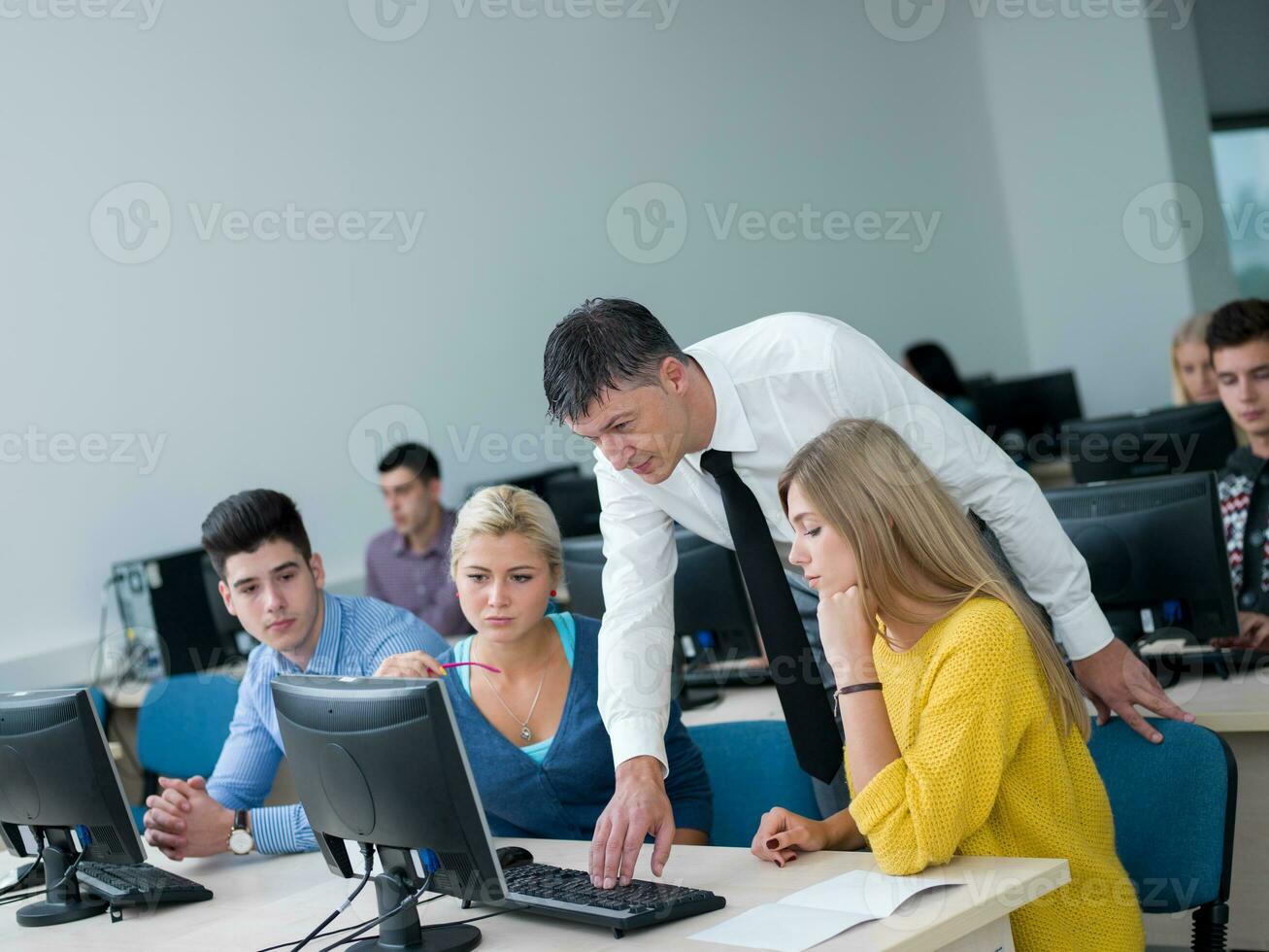 estudiantes con profesor en aula de laboratorio de computación foto