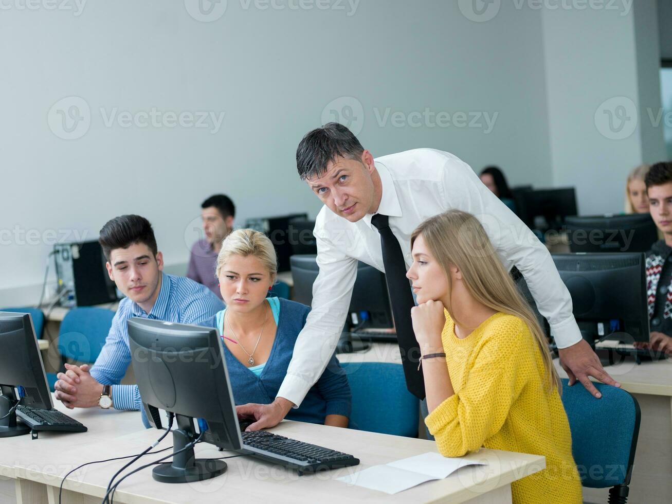 students with teacher  in computer lab classrom photo