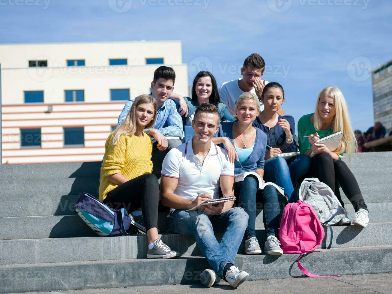 estudiantes afuera sentados en escalones foto