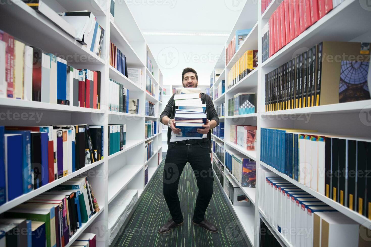 Student holding lot of books in school library photo