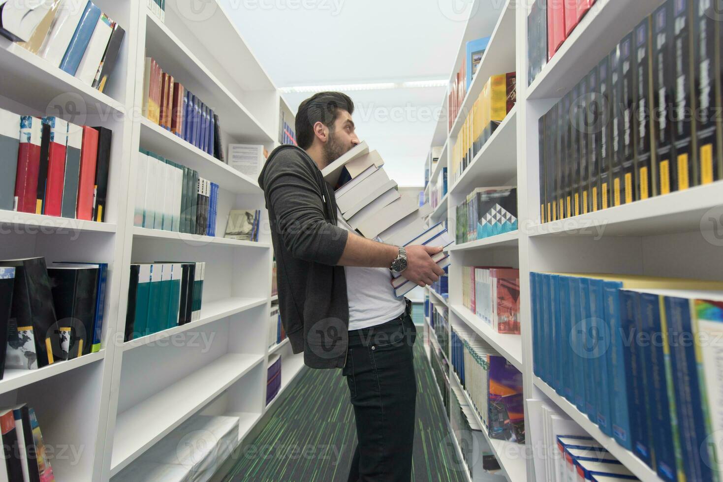 estudiante con muchos libros en la biblioteca escolar foto