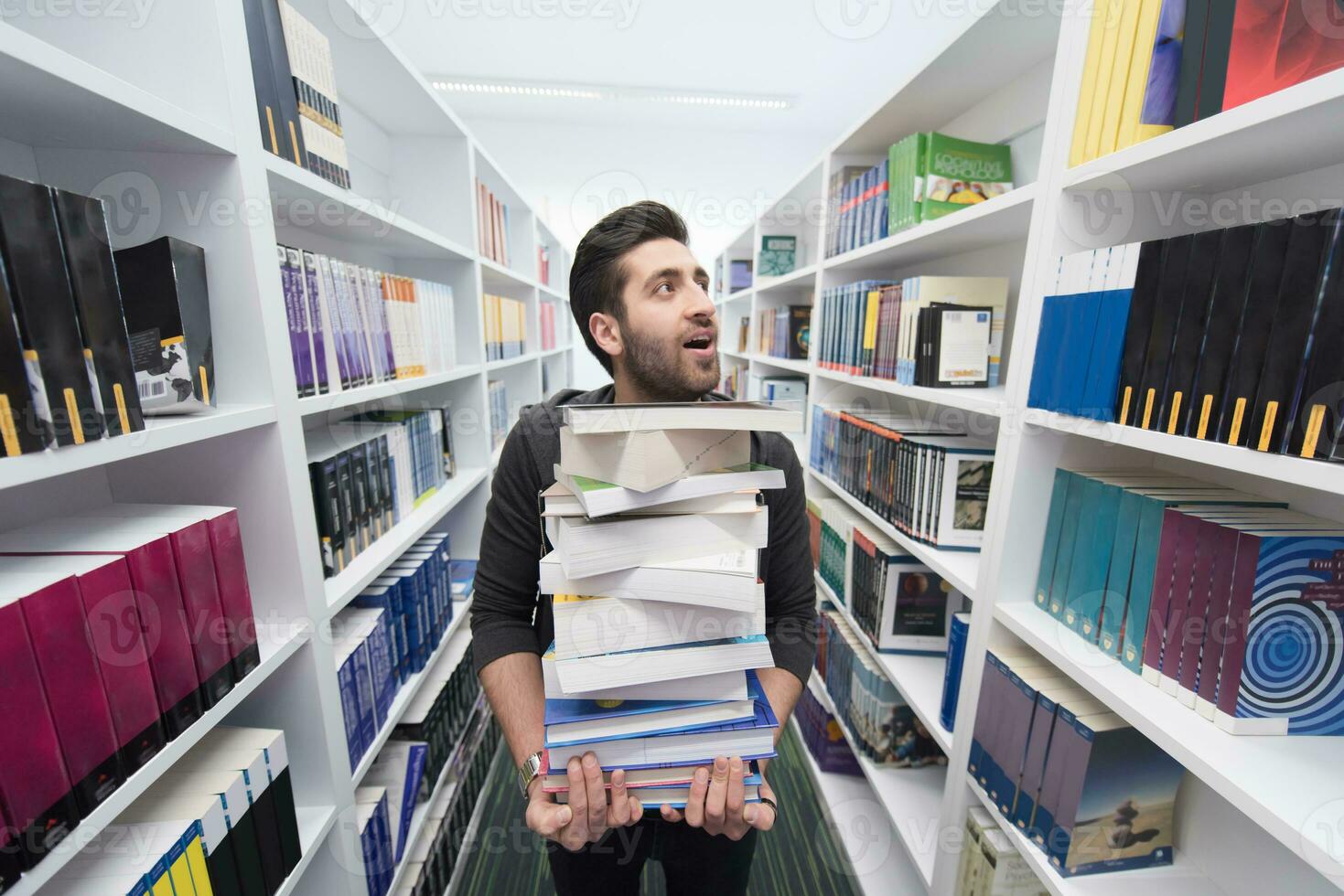 estudiante con muchos libros en la biblioteca escolar foto