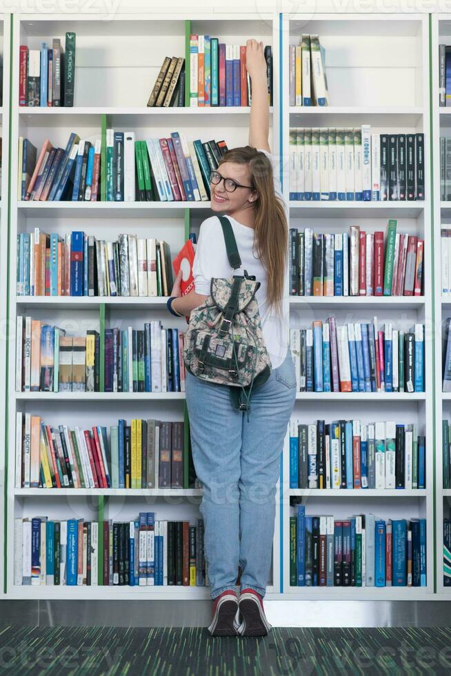 famale student selecting book to read in library photo