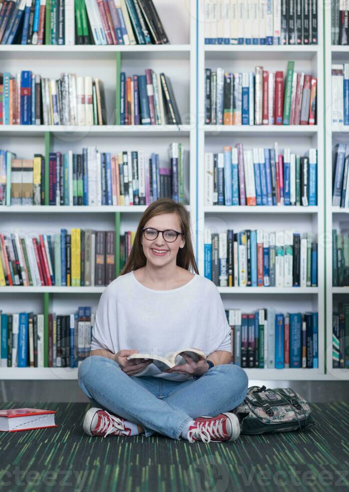 famale student reading book in library photo