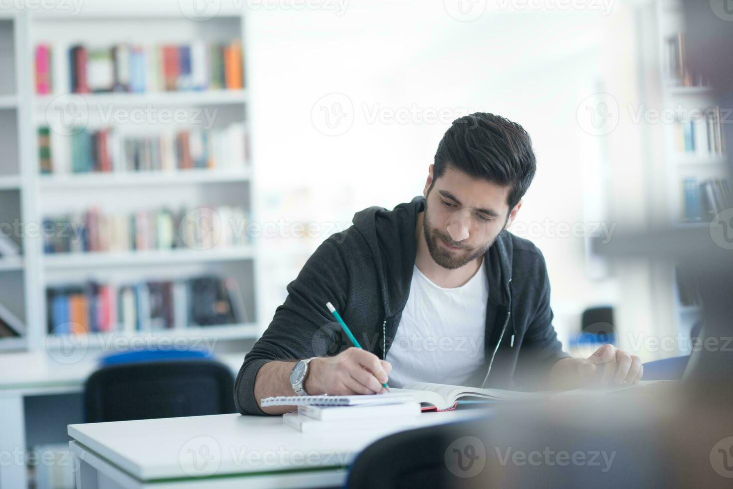 estudiante en la biblioteca escolar usando una computadora portátil para investigar foto