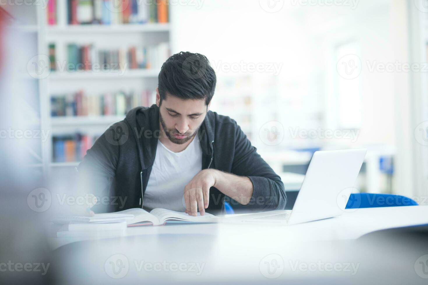 estudiante en la biblioteca escolar usando una computadora portátil para investigar foto