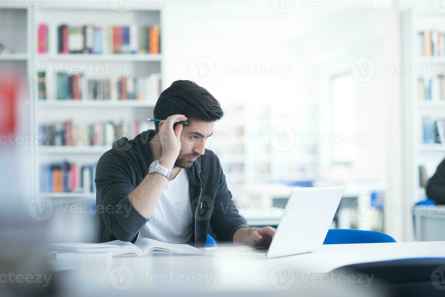 student in school library using laptop for research photo