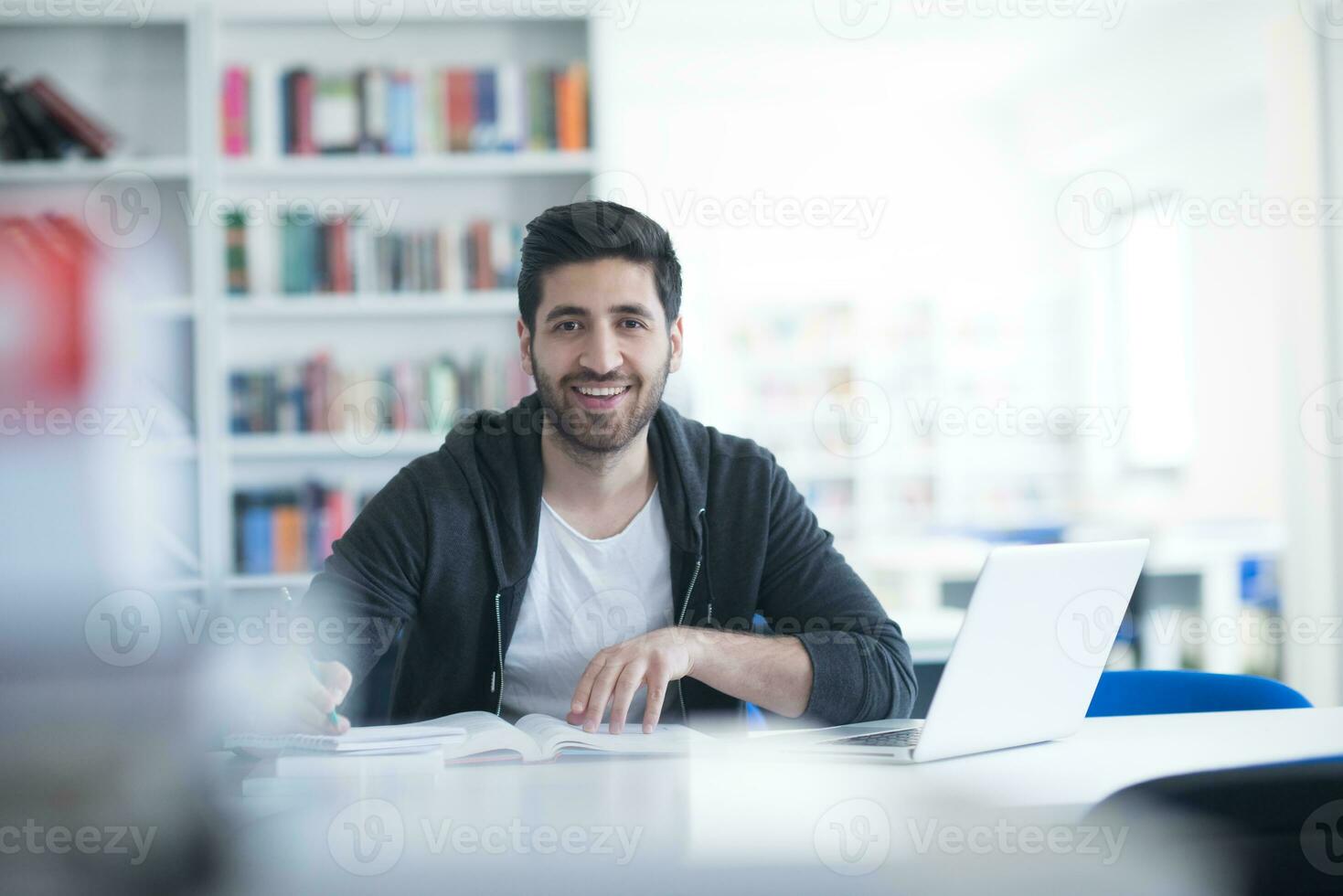 student in school library using laptop for research photo