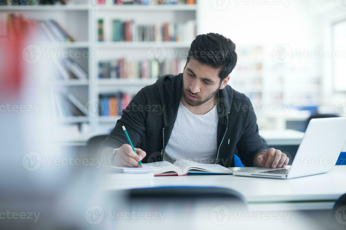 student in school library using laptop for research photo