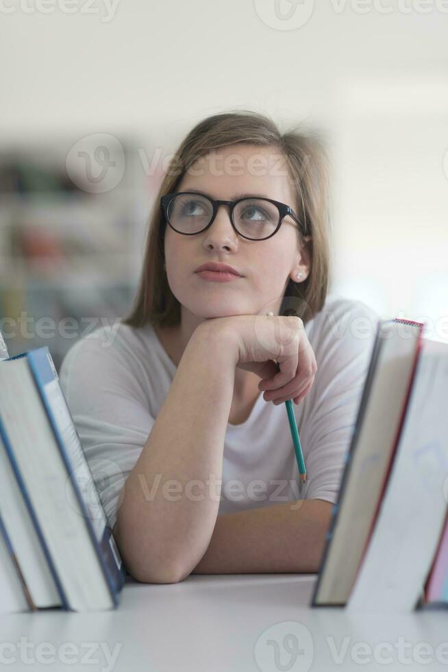 portrait of famale student selecting book to read in library photo